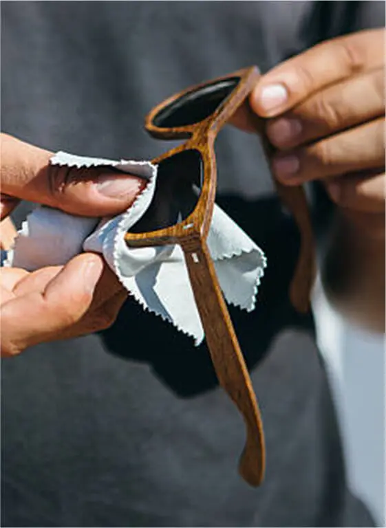 A man is taking care of his sunglasses